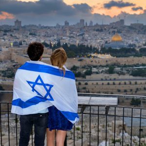 Una pareja envuelta en una bandera frente al Monte del Templo